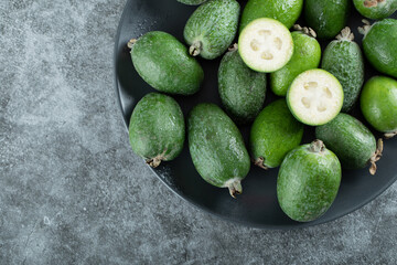 Plate of feijoa fruits on marble background