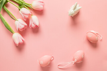 Easter pink composition for greeting card with eggs, bunny, tulips on pink background. View from above.