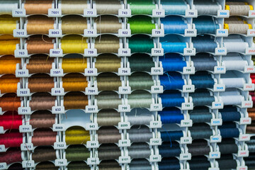 Sewing thread. thread spools background in textile store. Selective focus	
