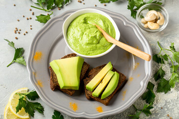 toasted rye bread with sliced avocado and herbs, healthy concept