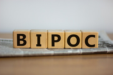BIPOC symbol. Abbreviation BIPOC, black, indigenous and people of color on wooden cubes. Beautiful white background. Copy space. Business and BIPOC, black, indigenous and people of color concept.