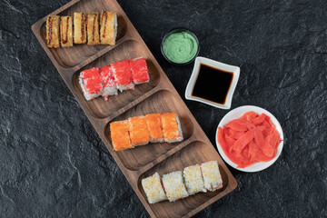 Sushi set on a wooden board with soy sauce and gingers