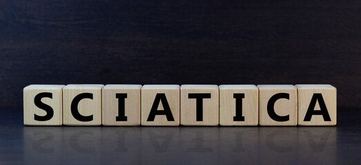 Sciatica symbol. Wooden cubes with word 'sciatica'. Beautiful grey background. Medical and sciatica concept. Copy space.