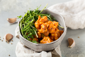 Fresh cauliflower salad with red sauce and herbs in bowl on the table, healthy food, health concept
