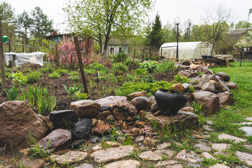 flower beds in spring are lined with natural stones in the garden after rain, close-up, selective focus, tinted image