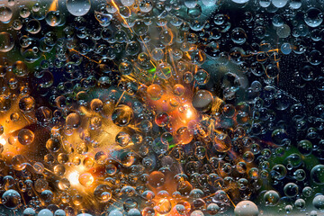 Multicolored spheres are illuminated by flashes of light and are located against a deep blue background. Space abstraction. 3D render.