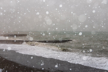 Beach on the Black Sea coast in winter. Sea waves and the snow, the strong snowstorm.
