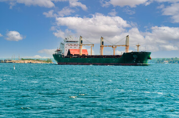 Single freight ship passing an island on the St. Lawrence River