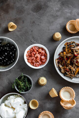Ingredients for canapes on a dark background. Cooking snacks. Shrimp, mushrooms and cream cheese.