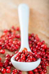 A spoon with red pepper corns