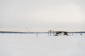 Abandoned building on the background of a snowy field.