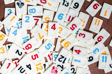 Rummi game tiles laying on a table simulating wood, in a mosaic style
