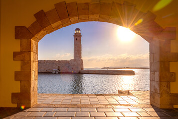 The Egyptian lighthouse at the old harbor of Rethimno through a frame of an arched door, Crete, Greece.