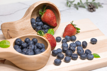 Fresh blueberries and strawberries in a wooden mug. Natural vitamins concept