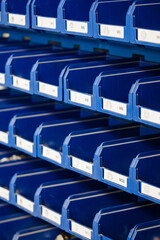 Row of plastic blue boxes in a warehouse.