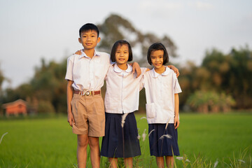 Children of student and wearing uniform playing in rice field on morning of countryside