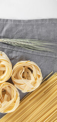 Variety of raw pasta on gray tablecloth