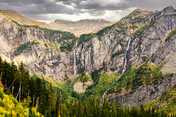 Obraz premium Avalanche Basin cliffs, Avalanche Creek and Monument Falls waterfall in Glacier National Park, Montana. Avalanche Lake is southwest of Bearhat Mountain and receives meltwater from Sperry Glacier.