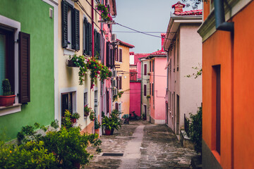 Fototapeta na wymiar colorful tiny houses in alley bright colourful street slovenia mediteranean