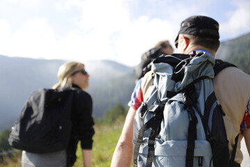 Eine Gruppe von den Wanderer gehen Berg hoch. Sie haben Rücksäcke auf dem Rücken. Wanderung in der Bergen, Schweiz