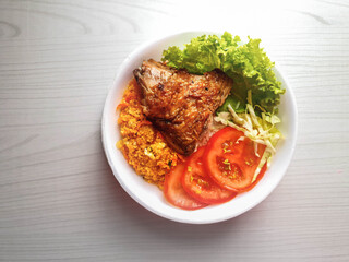 lunch box with roasted chicken, farofa, salad with tomato, cabbage and lettuce and rice in white styrofoam pot and background with space for text and 