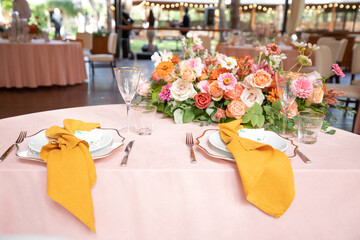 banquet table is decorated with plates, cutlery, glasses, candles and flower arrangements