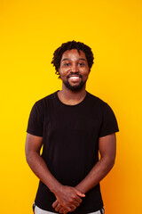 young handsome african american guy student posing cheerful and gesturing on yellow background, lifestyle people concept