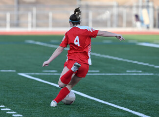Fototapeta premium Young athletic girl making an exciting play during a soccer game