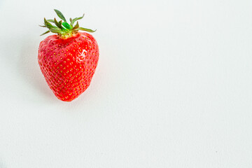 One bright strawberry on a white background, appetizing, beautiful, dietary. Place for text, copy space, flat lay