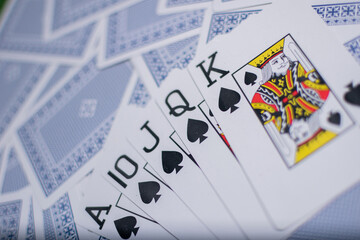 Closeup view of some Poker playing Cards over a green Texture wooden table
