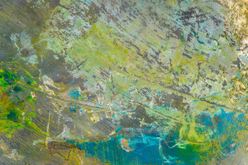 Fototapeta na wymiar colorful creative motley background: smudged residues of oil paints on a wooden palette, short focus, selective blur