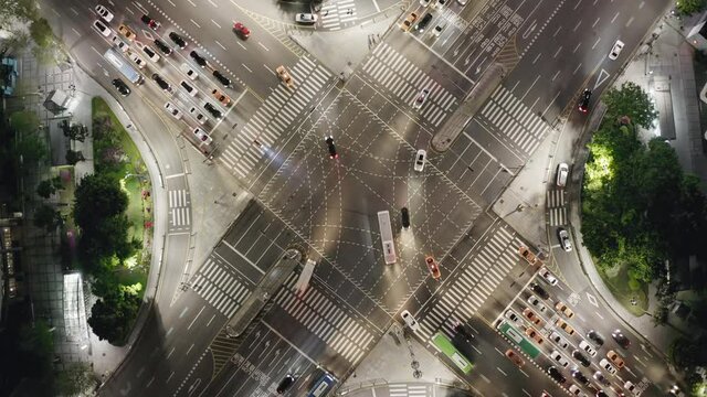 Beautiful aerial view to a crossroad in Seoul Gangnam District on the evening. Cars, buses and other vehicles turning at the busy intersection surrounded by modern skyscrapers.