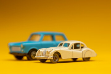 Obraz na płótnie Canvas Couple of oldtimer vintage miniature cars on clean colorful background. Studio colorful toy still life.