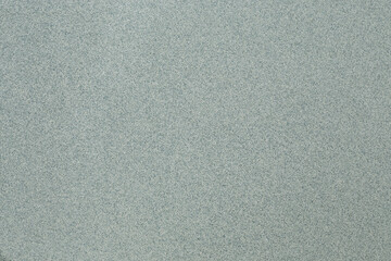 A macro shot of a primarily cool toned green background with gray and white speckling.