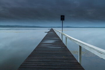 Obraz premium Rainy day sunrise waterscape with wharf