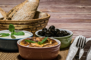 bread in a basket with yogurt, olives and moussaka-2