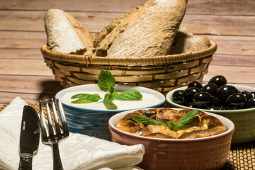 bread in a basket with yogurt, olives and moussaka-3