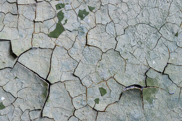 Peeling paint on the wall. Old concrete wall with cracked flaking paint. Weathered rough painted surface with patterns of cracks and peeling. High resolution texture for background and design. Closeup
