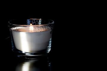 Bright white scented candle flame with dark background.
