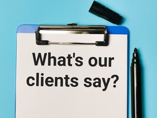 Phrase What is our clients say written on paper clipboard with pen. Business and economy concept.