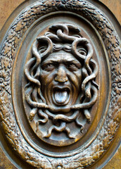 ornate medusa wood carved design on an old door