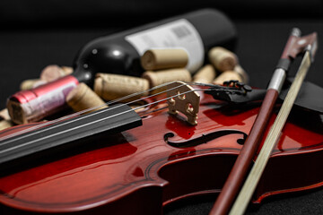 Close view of a classical small violin, strings and bridge over a dark black blanket background...