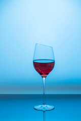 Close up view of red wine in glass isolated on blue background. 