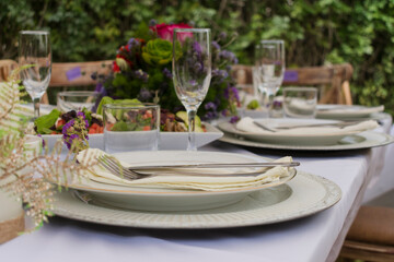 Elegant gold and white table with glasses and flowers.