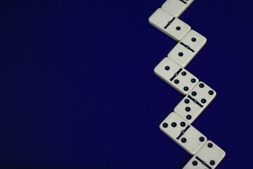Old fashioned dirty domino stands on a solid backround
