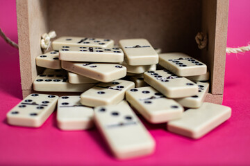 Old fashioned dirty domino on a box with pink solid backround
