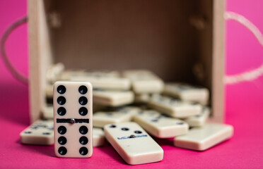 Old fashioned dirty domino on a box with pink solid backround
