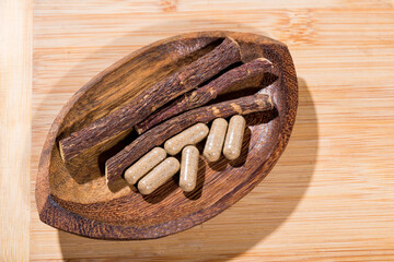 licorice root and tablets on black background