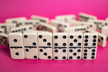 Old fashioned dirty domino on a box with pink solid backround
