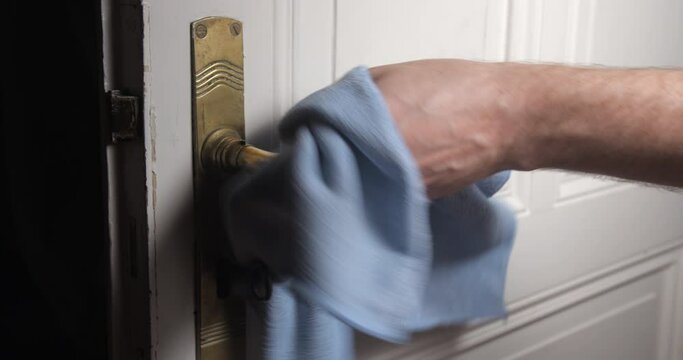 Door handle cleaning with man hand close up